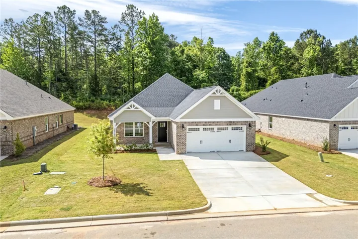 A newly constructed brick-front residence presents a welcoming facade with a neat driveway and attached garage.