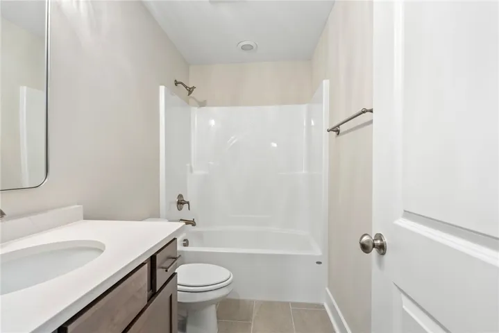 A well-appointed bathroom features a single vanity, a standard tub, and recessed lighting.
