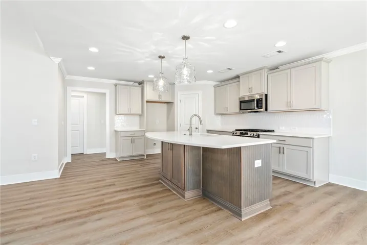 Culinary aspirations come alive in this kitchen, featuring an elegant island with a breakfast bar and modern appliances.