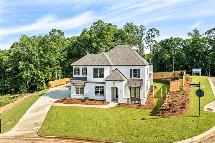 A striking white home with dark accents and a well-manicured lawn awaits.
