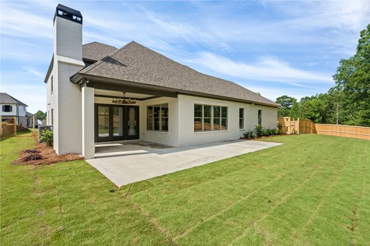 An inviting covered patio extends from the home's rear, leading to a newly sodded lawn and privacy fencing.