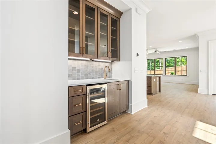 A well-appointed wet bar with a wine cooler complements the open-concept living area.