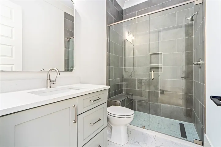 A well-appointed bath features a spacious glass-enclosed shower.