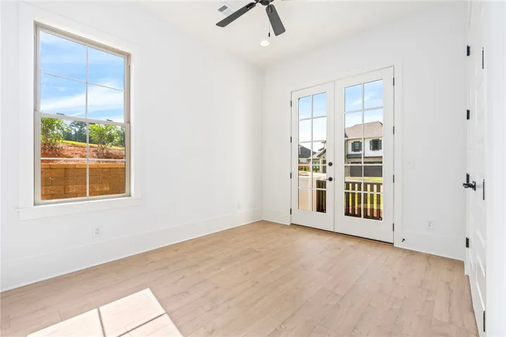 Natural light pours into this bright room featuring durable wood flooring and elegant French doors.
