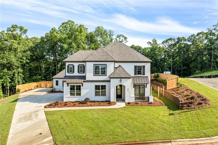 Grand two-story residence with a classic facade, nestled among mature trees and manicured lawns.