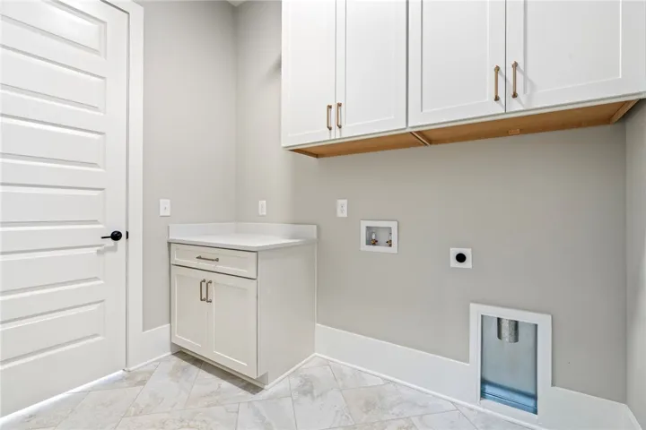 Ample cabinetry and a functional countertop create a convenient and organized space for laundry.