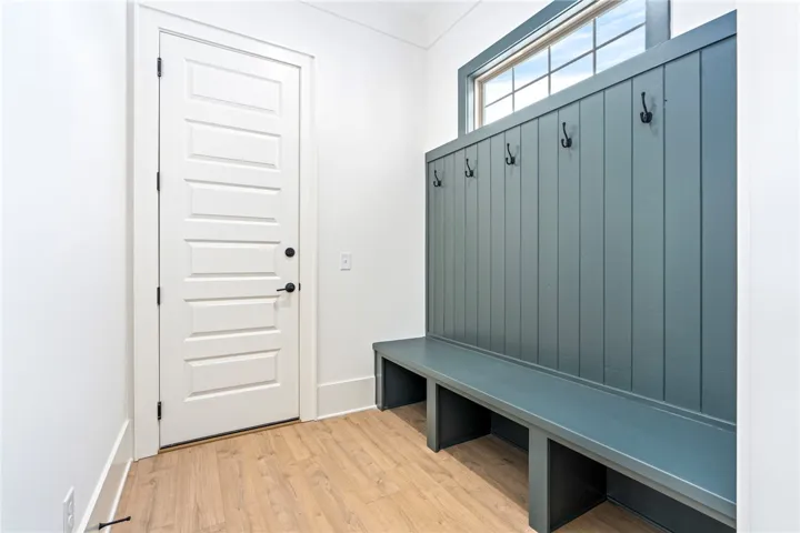 A convenient mudroom entryway offers ample storage with a built-in bench and coat hooks.