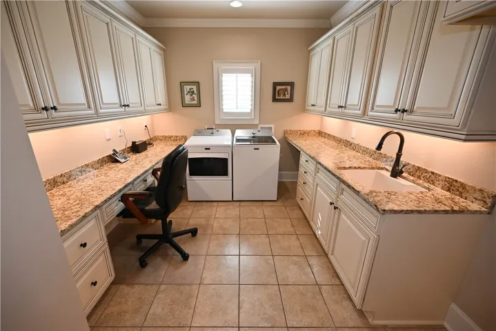 Laundry area with plenty of storage, a sink and built-in desk!