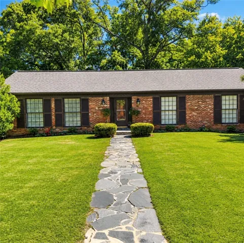 A classic brick exterior with a welcoming stone path leads to this charming residence.