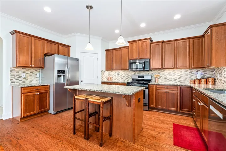 This warm kitchen offers a central island, rich wood cabinetry, and stainless steel appliances.