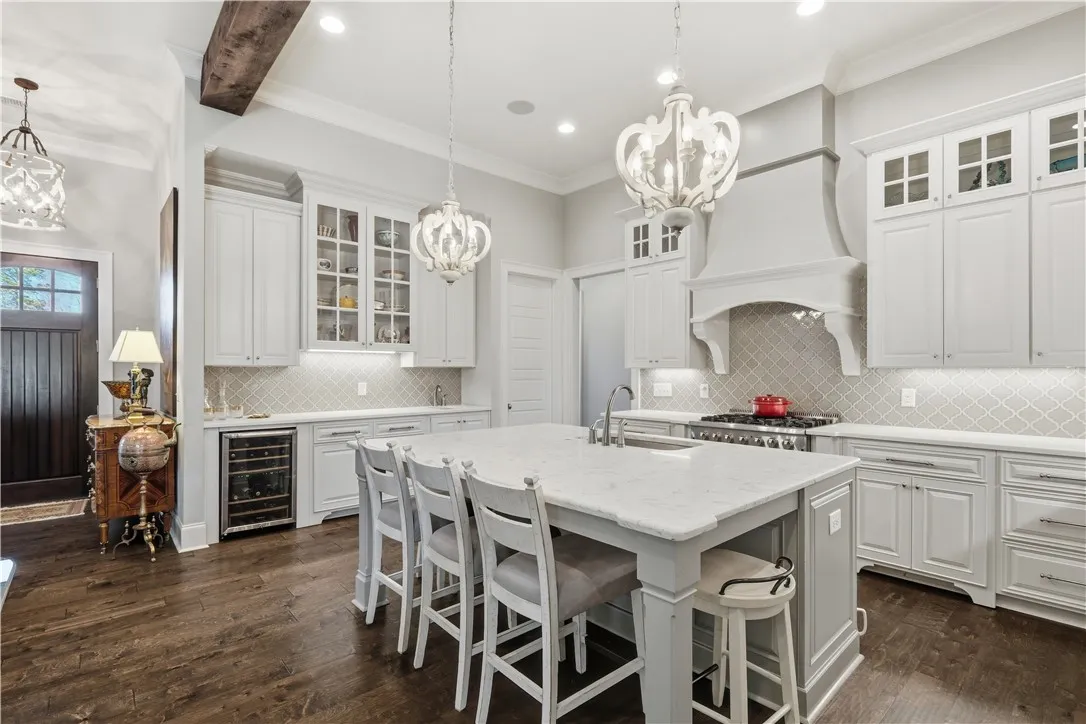 The wet bar features a wine fridge, bar sink, and both glass-front and concealed cabinetry.