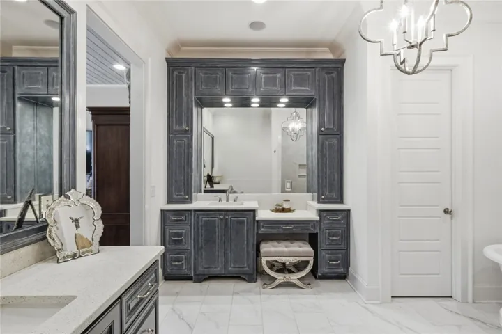 Two generous vanities—one complete with a dressing table and linen towers—provide ample storage.