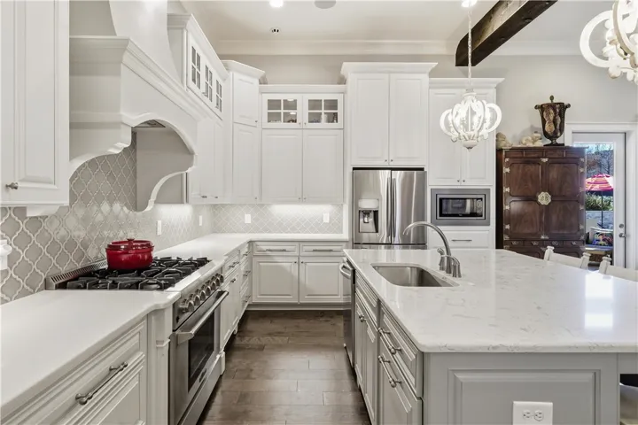 Quartz countertops and an elegant backsplash extend throughout the kitchen.