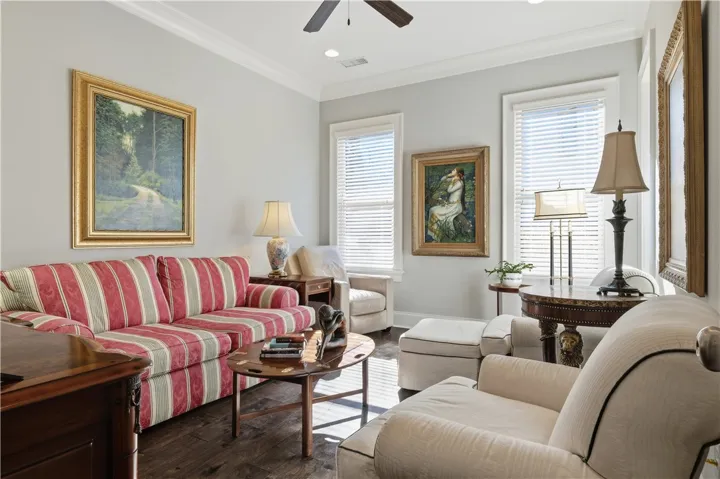 Bedroom 3 is currently styled as a cozy sitting room, with wood floors, double windows, and a walk-in closet allowing for versatile use.