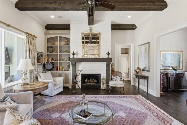 A substantial gas fireplace with a shiplap surround, paired with built-in cabinetry, anchors the great room.