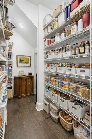 The walk-in pantry offers abundant storage and provides access to a dedicated safe room.