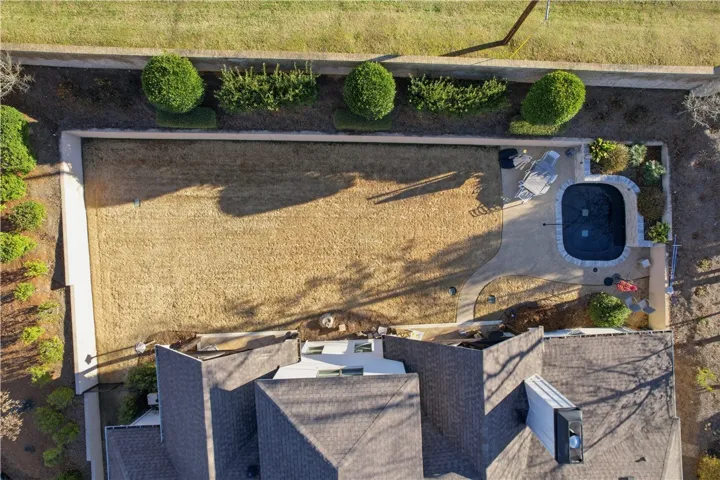 This aerial view showcases the yard’s privacy—created by walls, landscaping, and fencing—while also highlighting its size and the thoughtful placement of the pool.