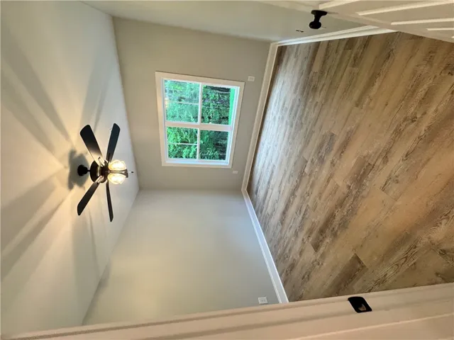 This bright bedroom features a ceiling fan and elegant flooring, ready for your personal touch.
