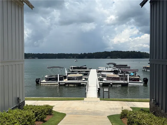 Boats moored at a waterfront dock under an open sky, framed by modern siding.