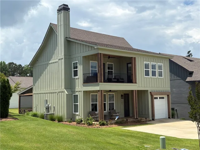 Board and batten siding defines this inviting residence with its two-story porch and integral garage.