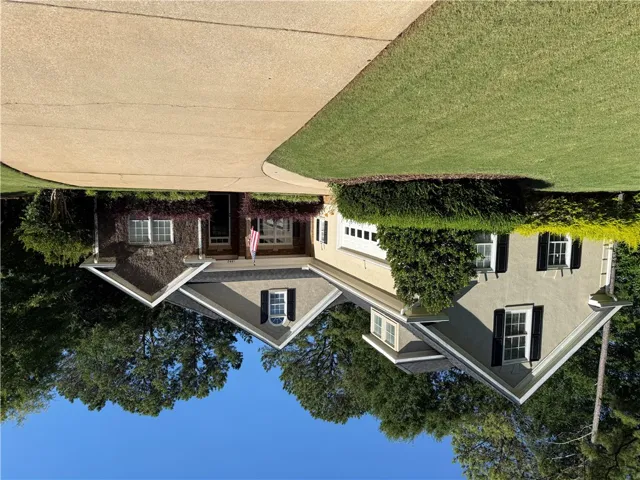 A classic facade with a sweeping driveway and manicured landscaping creates a grand welcome.