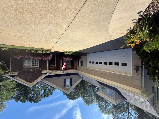 A welcoming facade with a garage, complemented by well-maintained landscaping and mature trees.