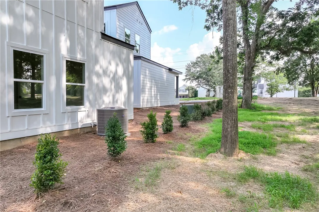 Board and batten siding graces this newly constructed home with a serene, natural backdrop.