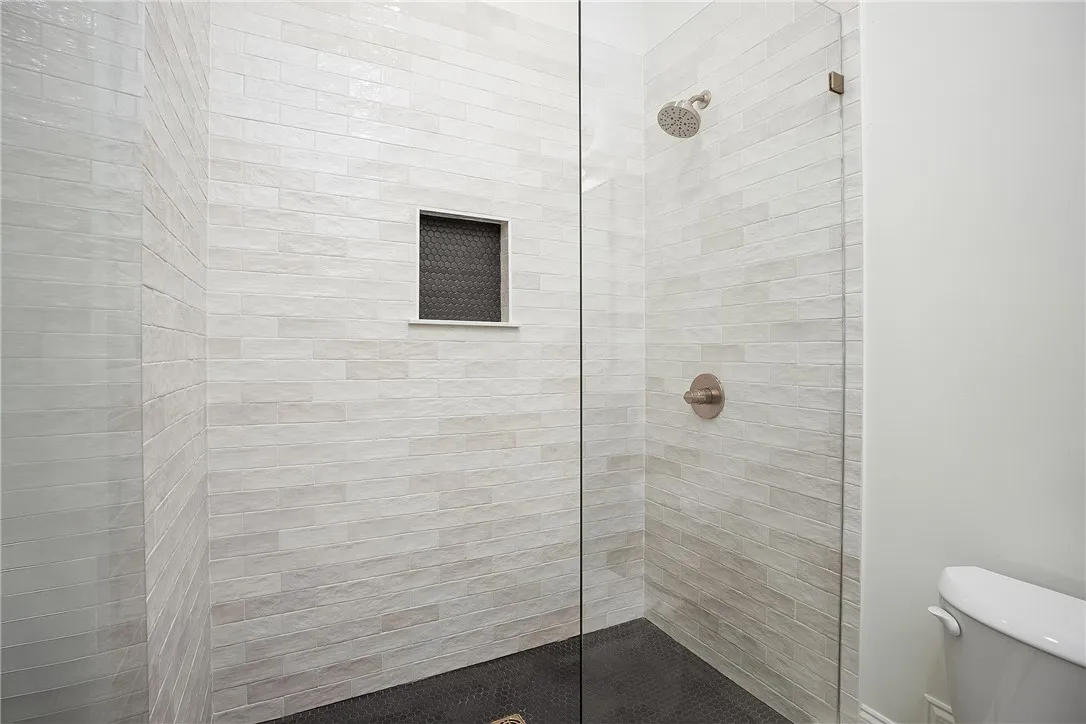 A sleek, tiled shower with a convenient built-in niche and a modern glass enclosure.