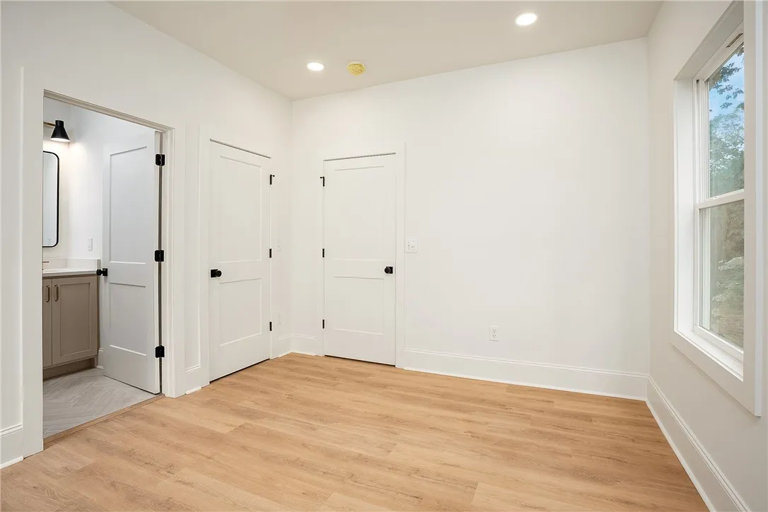 A well-proportioned interior space offers warm wood-look flooring and clean white walls, creating an inviting canvas.
