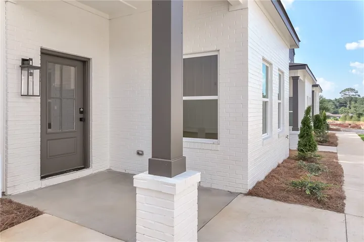 A welcoming entry, with a painted brick facade and a shaded concrete porch.