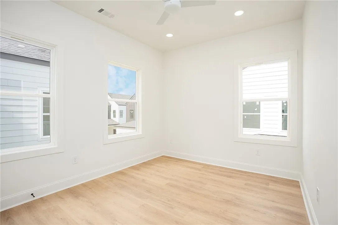 A well-lit room showcasing crisp walls and light-toned hardwood flooring.