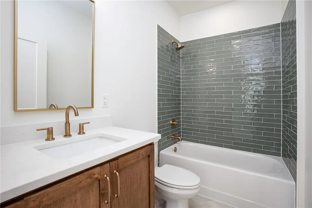 A well-appointed bathroom features a sleek vanity, elegant bronze fixtures, and striking subway tile.
