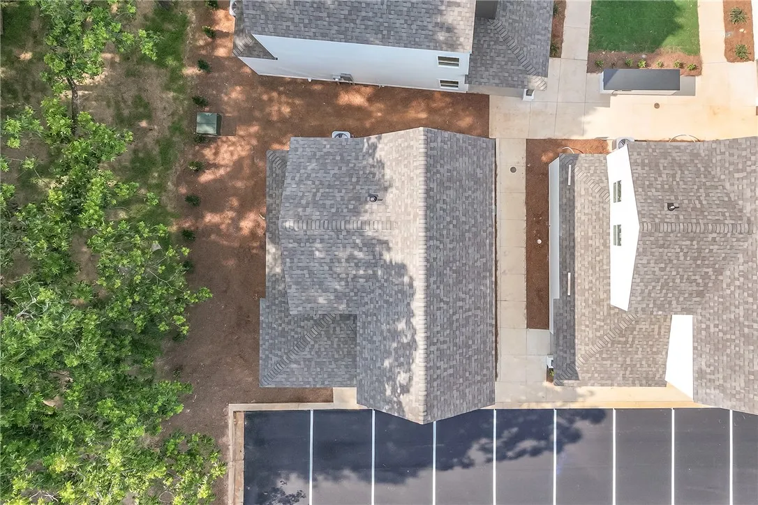 An aerial perspective reveals a neatly organized residential development with well-maintained roofing and dedicated parking.