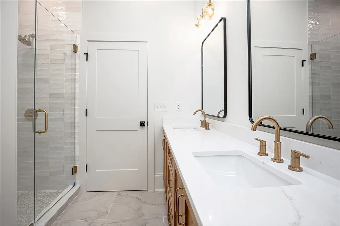 Double vanity and a spacious glass-enclosed shower create a practical bathroom retreat.