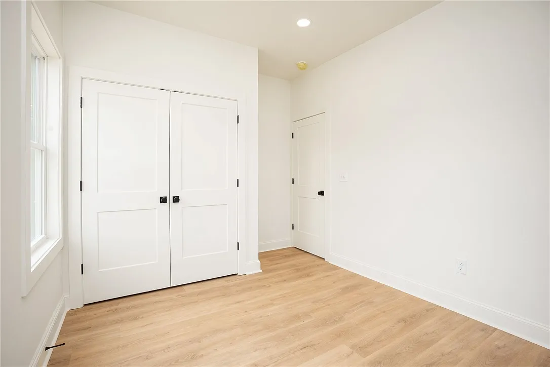 Bright, unadorned room with light wood-style flooring, ready for personalization.