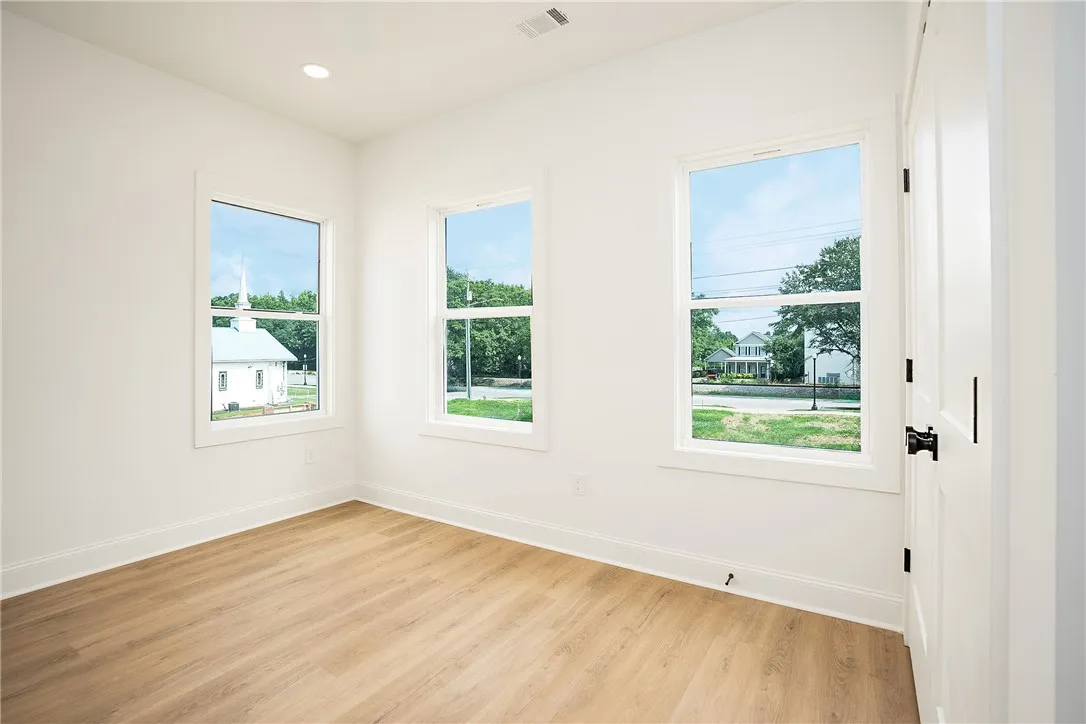 Three generous windows illuminate this versatile space, perfect for any need.