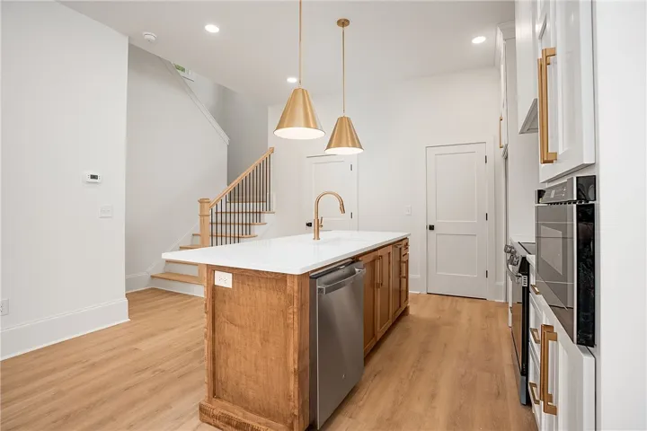 A well-appointed kitchen island with sleek gold fixtures and modern appliances anchors this bright culinary space.