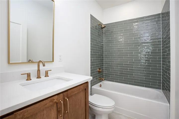 A well-appointed bathroom features a sleek vanity, elegant bronze fixtures, and striking subway tile.