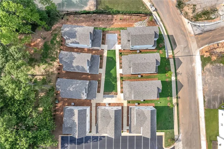 An aerial perspective showcases a vibrant new development featuring multiple structures and well-maintained grounds.
