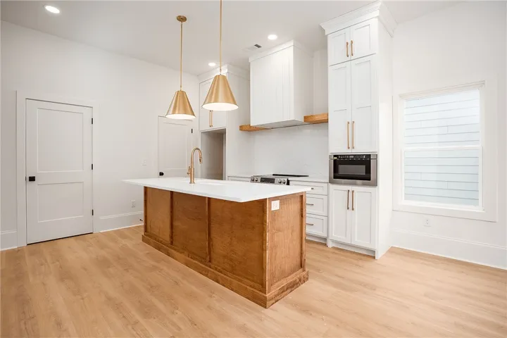 Culinary dreams come alive in this kitchen, featuring a spacious island and sophisticated golden accents.