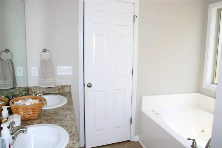 Double vanities and a corner soaking tub define this relaxing bathroom oasis.