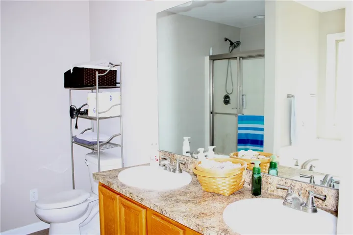 A well-appointed bathroom features a double vanity and a glass-enclosed shower for daily routines.