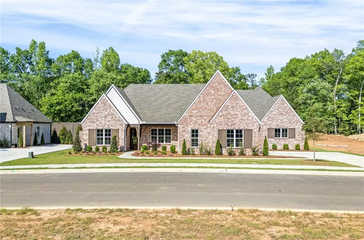 This charming residence showcases a classic brick exterior with welcoming landscaping and ample curb appeal.