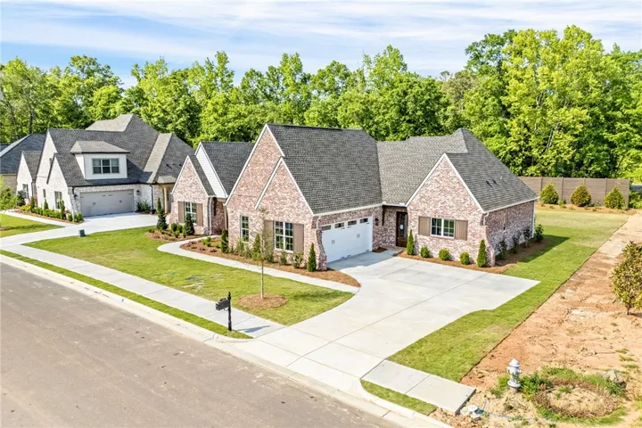 This newly constructed home boasts a charming brick exterior and an inviting attached garage.