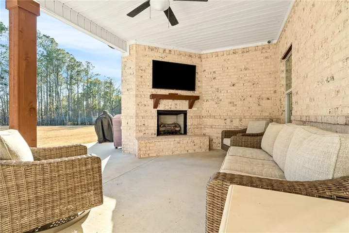 A covered back porch with fireplace extends the living area