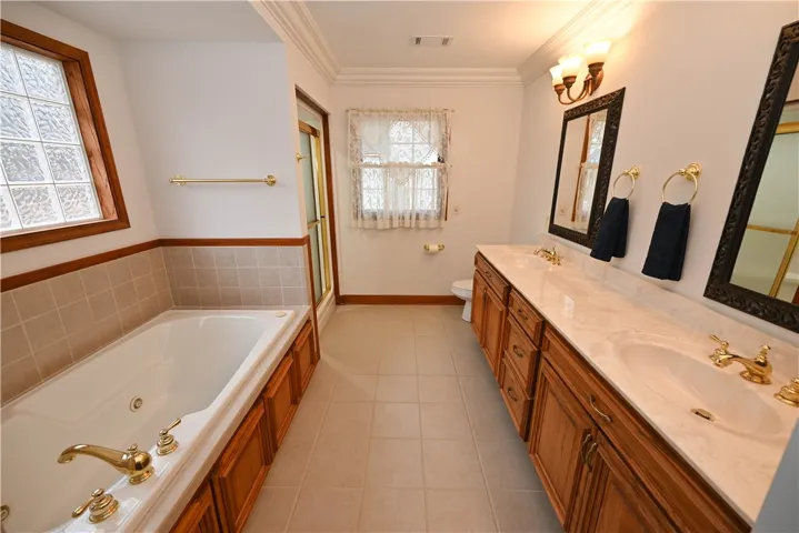 primary bath includes an oversized tub, step in shower, double sink vanity and two linen closets