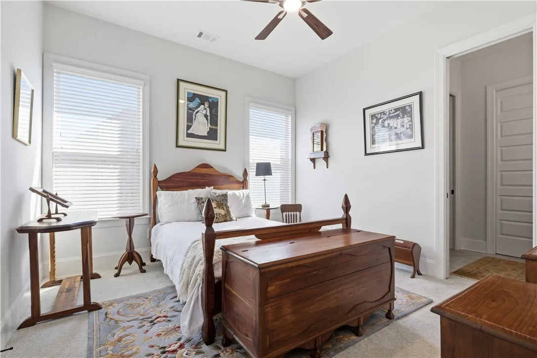 In bedroom 3, the bed is beautifully positioned between two tall windows, and the room enjoys direct access to a full bath.