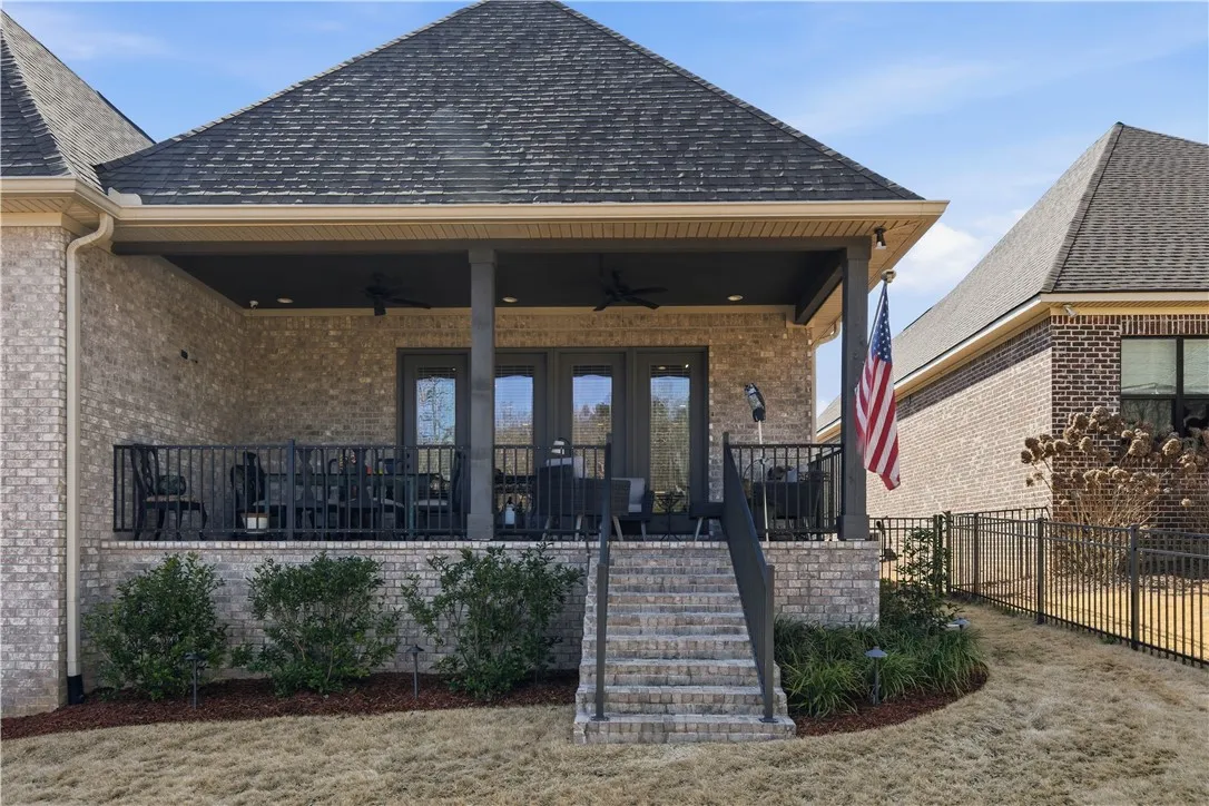The yard, enclosed by a decorative aluminum fence, is thoughtfully landscaped.