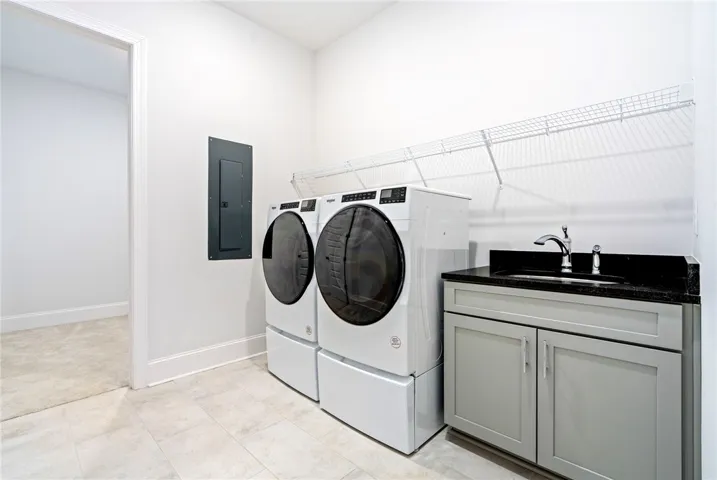 Generous space, cabinetry, shelving, and appliances already in place make this laundry room as functional as it is well-equipped.