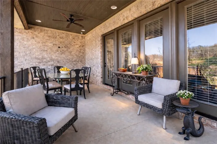 The rear porch offers generous space for multiple seating arrangements, while the four-panel door system creates a strong connection between indoor and outdoor living.